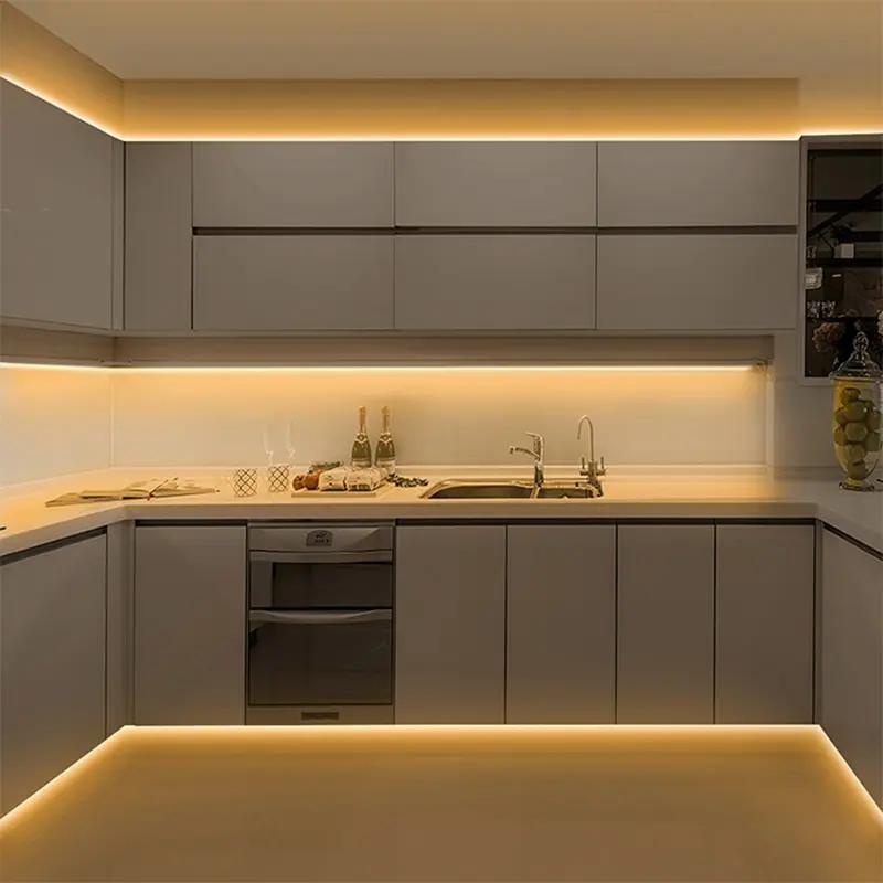 Modern kitchen with warm white COB LED strip lighting under cabinets and along ceiling edges creating soft ambient illumination