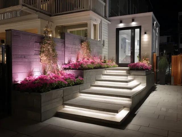 Outdoor residential staircase illuminated with white COB LED strip lighting integrated into steps and garden walls with accent lighting on plants