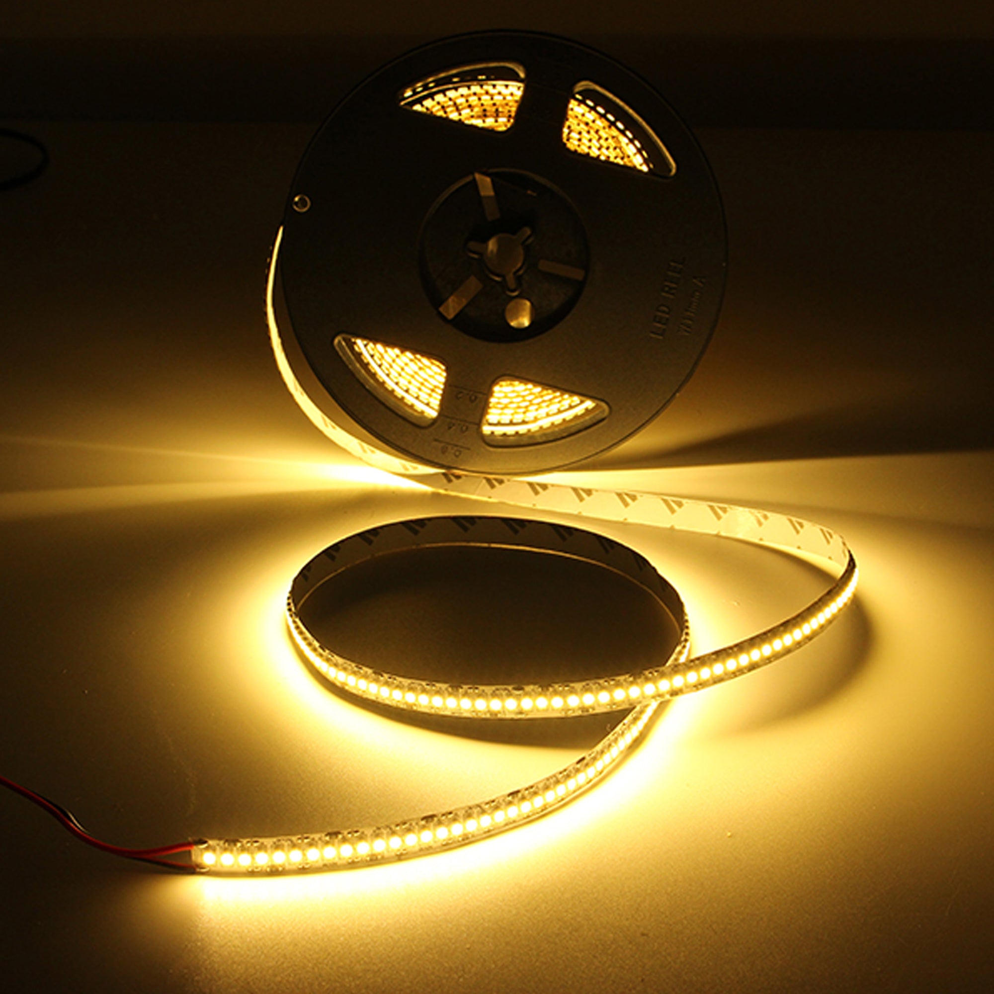 24V SMD LED strip light illuminated showing warm white linear lighting output on reel