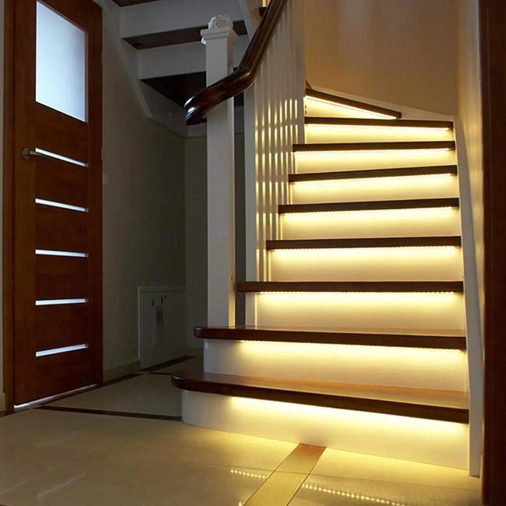 Indoor staircase with warm white SMD LED strip lighting installed under each step creating soft ambient illumination and enhanced safety visibility